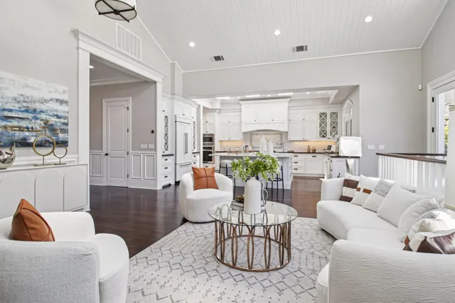 a large white kitchen with a large window a sink and cabinets