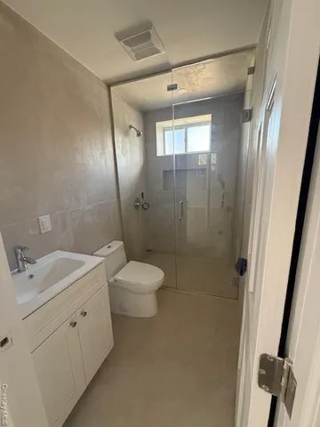 a spacious bathroom with a double vanity sink toilet and shower