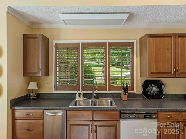 a kitchen with stainless steel appliances granite countertop a sink a stove and a microwave