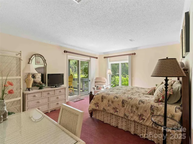 a bedroom with a bed a large window and flat screen tv