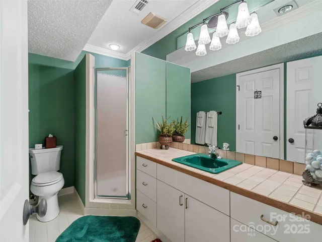 a spacious bathroom with a granite countertop sink a toilet and a mirror