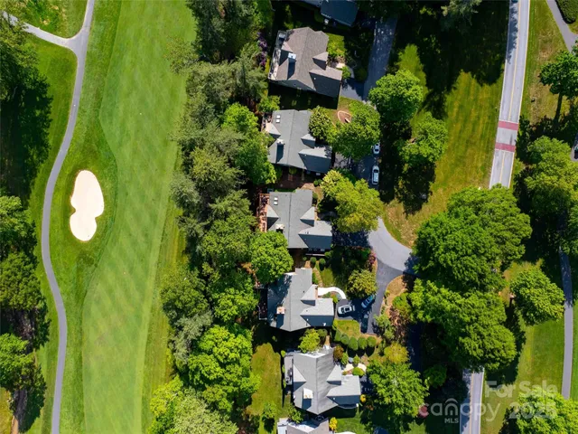 an aerial view of a house with a yard and lake view