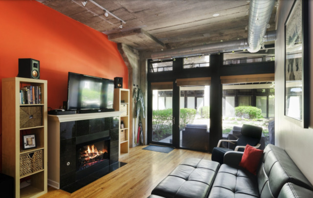 1110 West 15th Street, Unit 113 Chicago, IL 60608 - Photo 2 of 14 a living room with furniture a flat screen tv and a fireplace