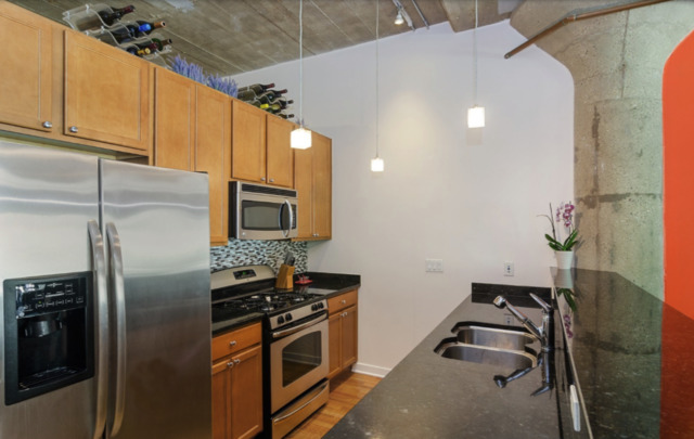 1110 West 15th Street, Unit 113 Chicago, IL 60608 - Photo 4 of 14 a kitchen with stainless steel appliances granite countertop a refrigerator and a stove top oven