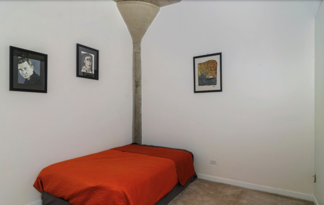 1110 West 15th Street, Unit 113 Chicago, IL 60608 - Photo 8 of 14 a blue bed sitting in a bedroom next to a small wall