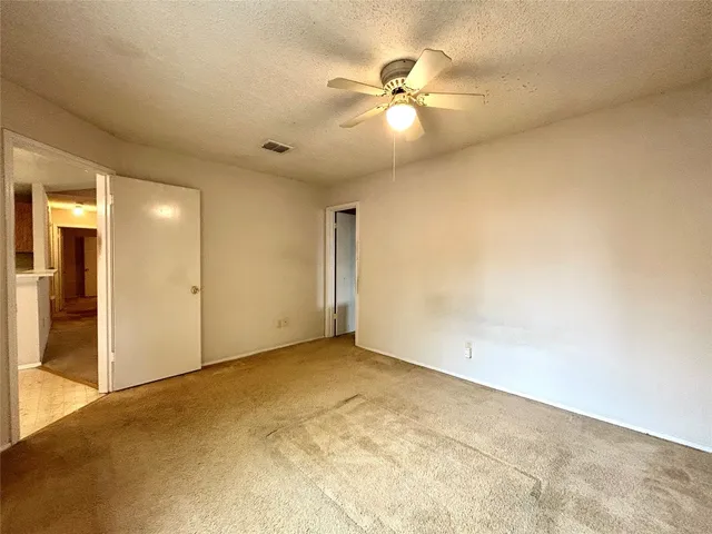 an empty room with a ceiling fan and a window