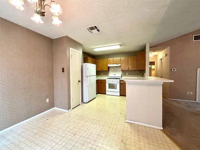 a view of a kitchen cabinets and a refrigerator