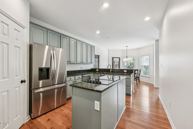 a kitchen with white cabinets and wooden floor