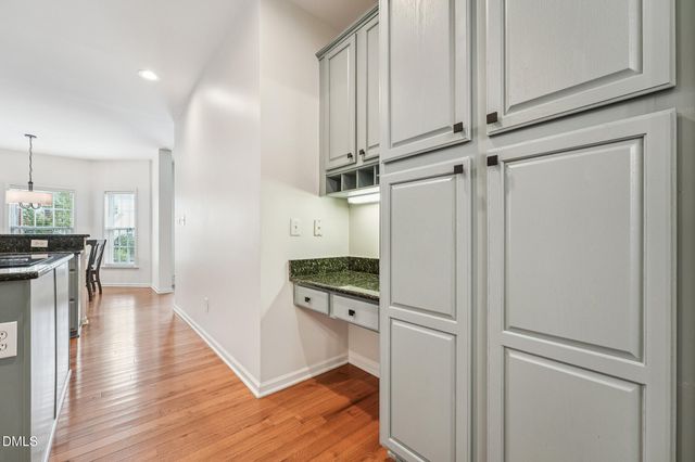 a kitchen with stainless steel appliances granite countertop a stove top oven a sink dishwasher and a refrigerator with wooden floor