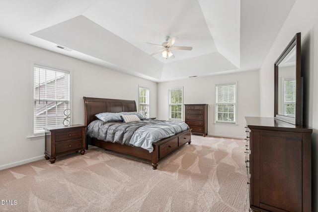 a bedroom with a large bed and a chandelier