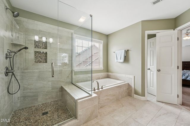 a spacious bathroom with a tub sink shower and mirror