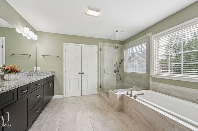 a bathroom with a granite countertop sink a large mirror and a bathtub