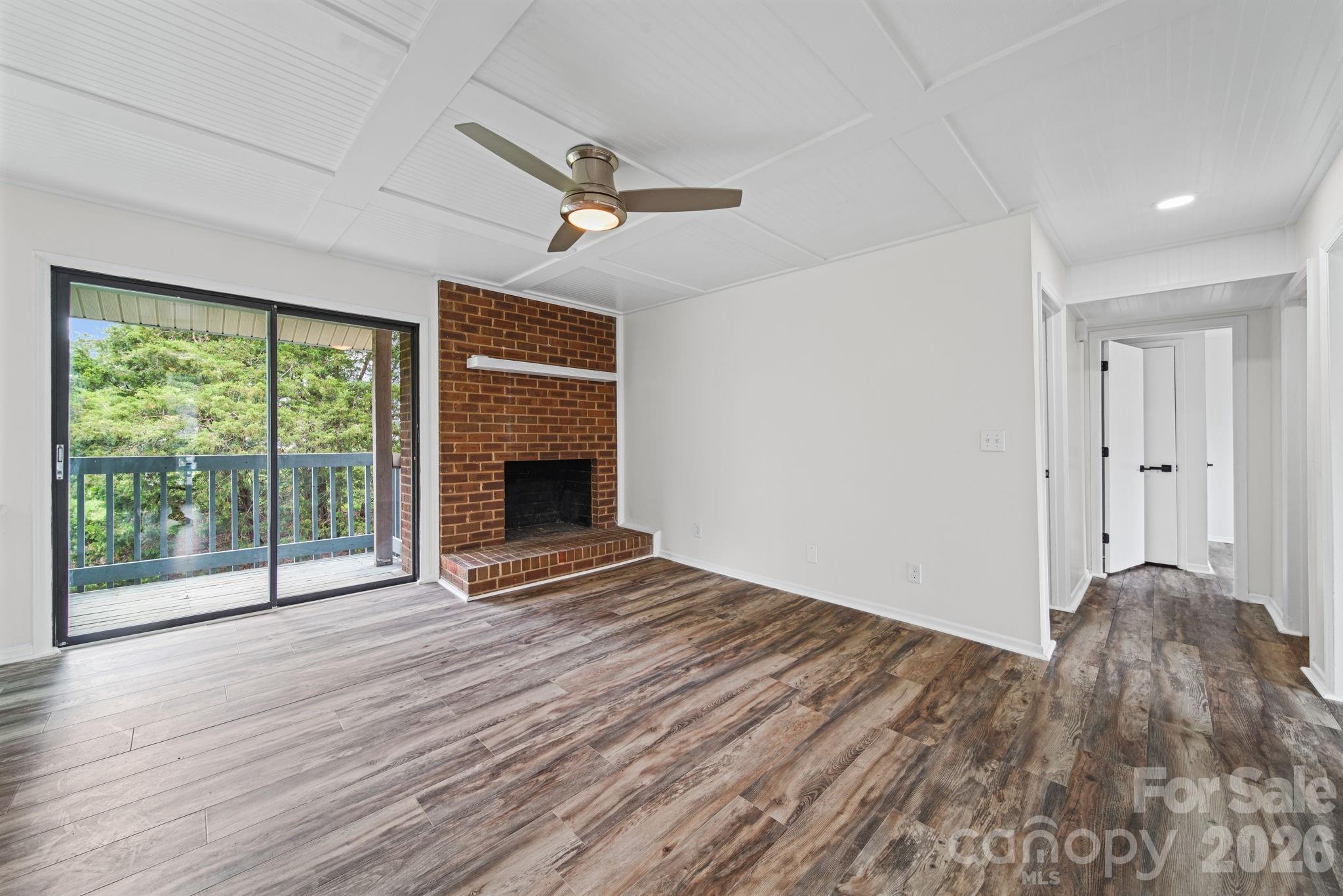 11023 Harrowfield Road Charlotte, NC 28226 - Photo 6 of 32 a view of empty room with wooden floor and fireplace
