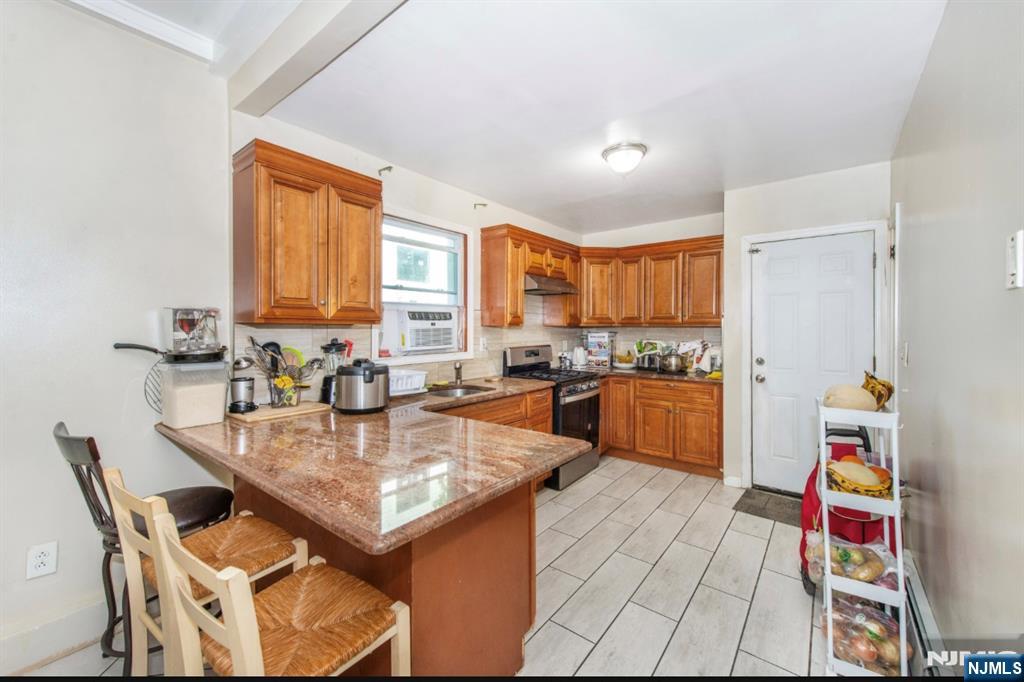337-379 Ellison Street Paterson, NJ 07501 - Photo 13 of 27 a kitchen with stainless steel appliances granite countertop a sink counter space and a window