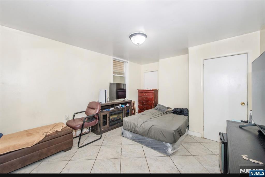 337-379 Ellison Street Paterson, NJ 07501 - Photo 14 of 27 a bedroom with furniture and a lamp