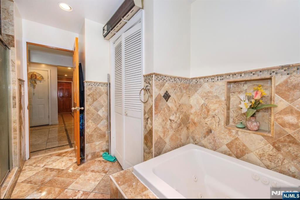 337-379 Ellison Street Paterson, NJ 07501 - Photo 20 of 27 a bathroom with a bathtub and shower