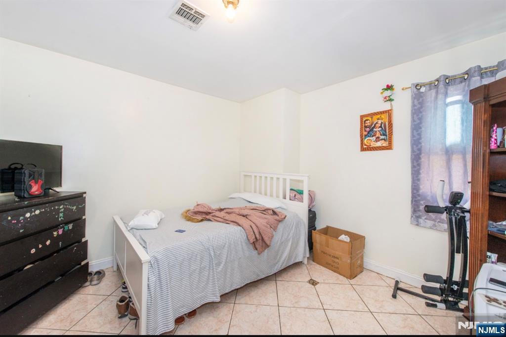 337-379 Ellison Street Paterson, NJ 07501 - Photo 21 of 27 a bed room with a bed and a tv