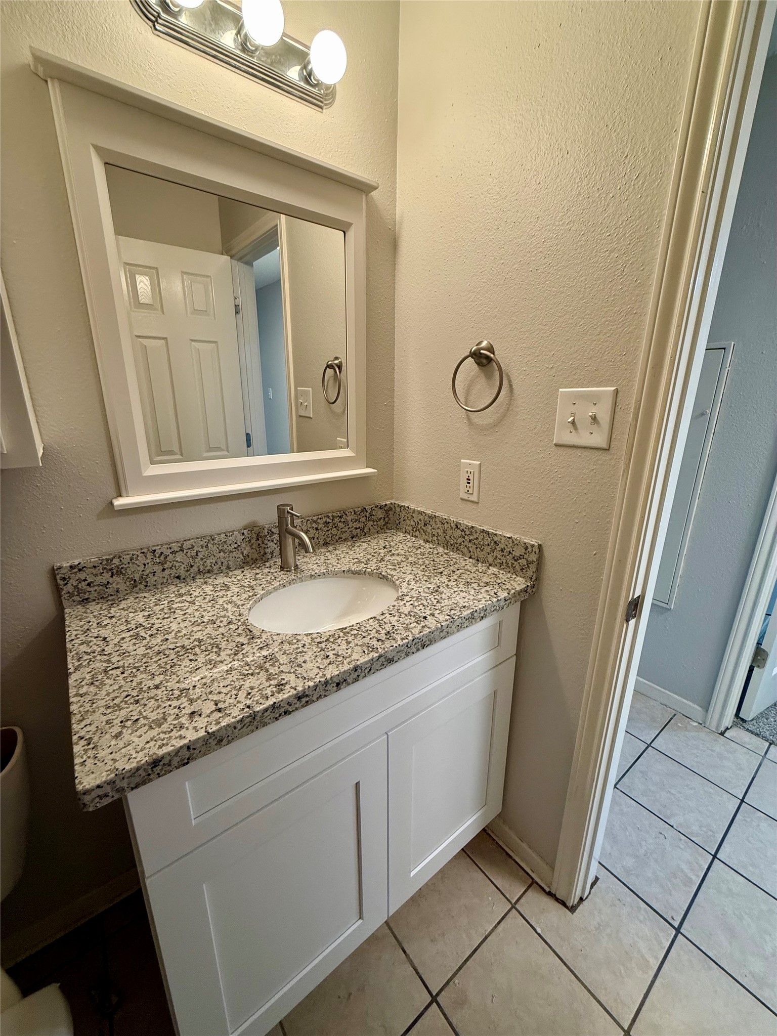 25144 Budde Road, Unit 7 Spring, TX 77380 - Photo 6 of 7 a bathroom with a granite countertop sink and a mirror