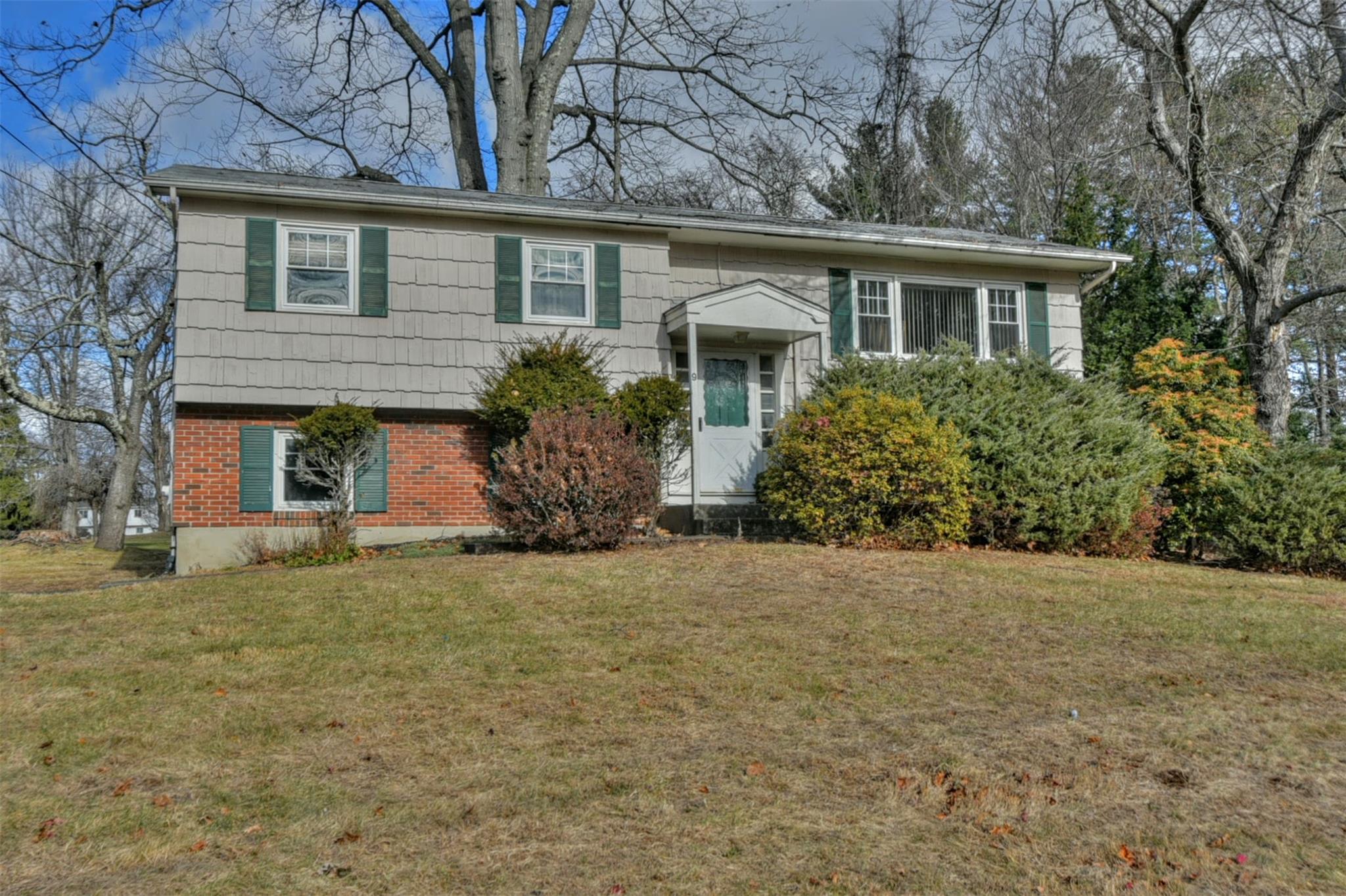 a front view of house with yard and trees around