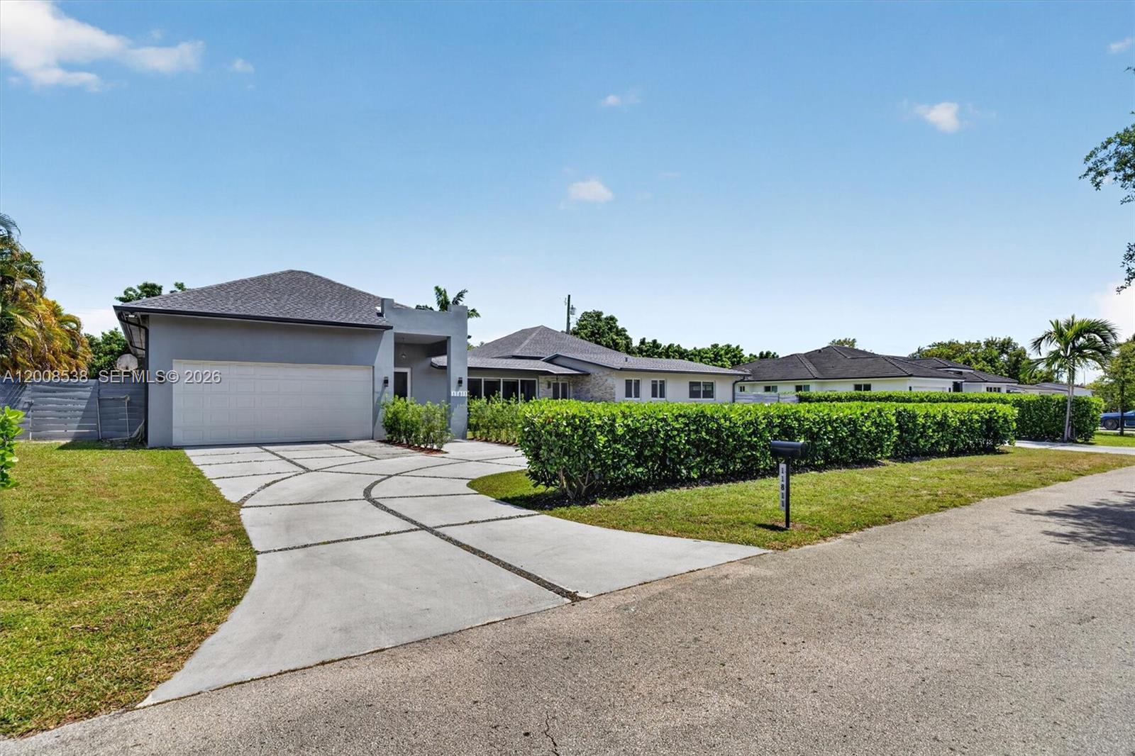 11811 Southwest 82nd Road Miami, FL 33156 - Photo 3 of 63 a front view of a house with a yard and garage