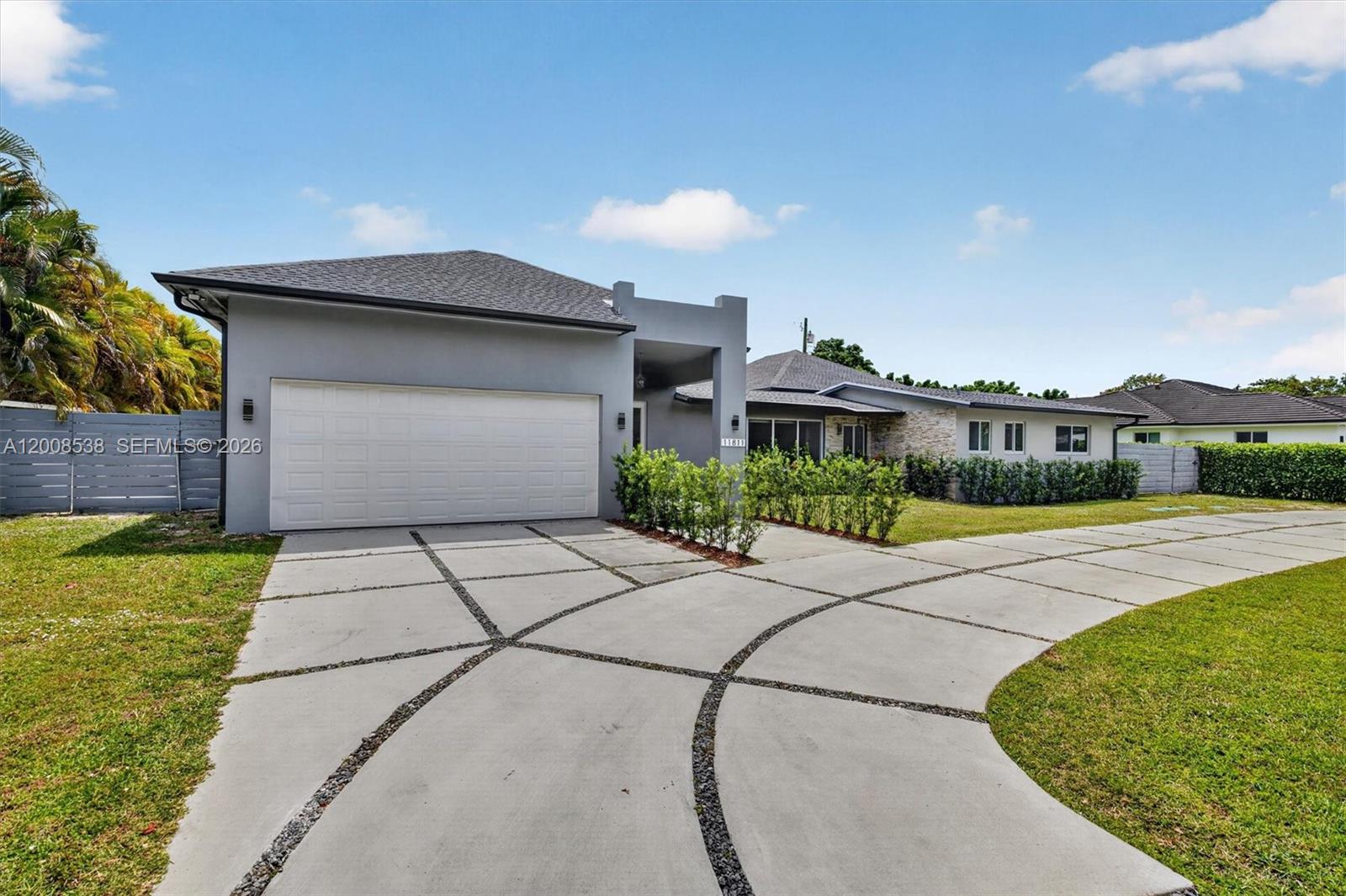11811 Southwest 82nd Road Miami, FL 33156 - Photo 5 of 63 a front view of a house with a yard and garage