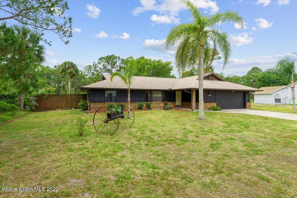 224 Rheine Road Northwest Palm Bay, FL 32907 - Photo 2 of 32 a front view of a house with garden