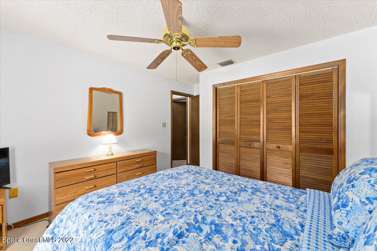 224 Rheine Road Northwest Palm Bay, FL 32907 - Photo 24 of 32 a bedroom with a bed and a dresser