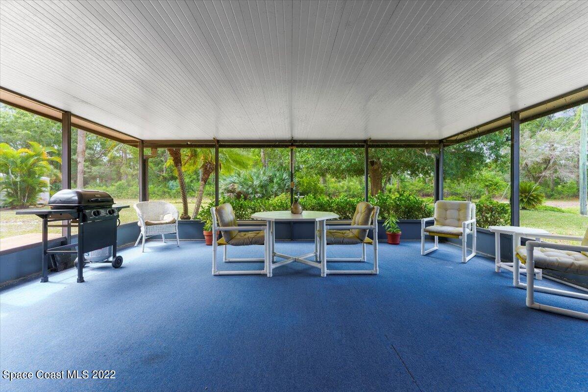 224 Rheine Road Northwest Palm Bay, FL 32907 - Photo 26 of 32 a living room with furniture and a floor to ceiling window