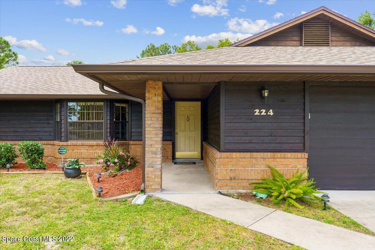 224 Rheine Road Northwest Palm Bay, FL 32907 - Photo 3 of 32 a front view of a house with garden