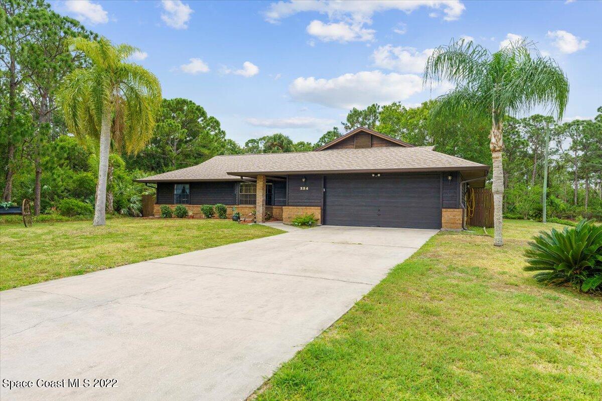 224 Rheine Road Northwest Palm Bay, FL 32907 - Photo 31 of 32 a front view of a house with a garden