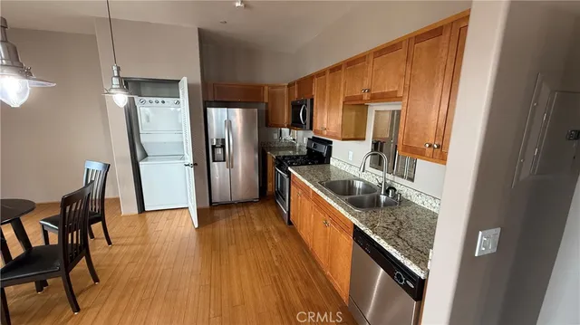 a kitchen with stainless steel appliances granite countertop wooden cabinets a sink and a refrigerator