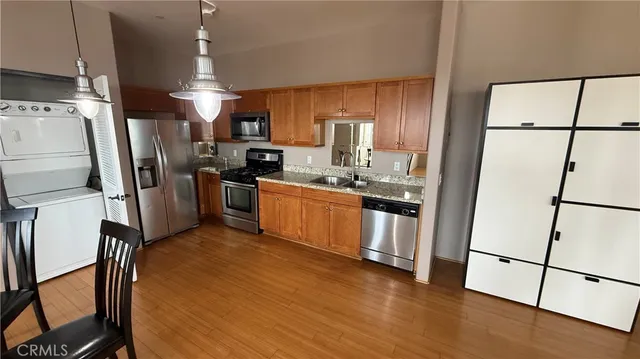 a kitchen with stainless steel appliances a refrigerator a sink a stove a microwave a sink and a refrigerator