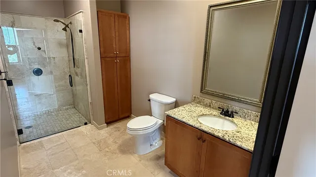 a bathroom with a granite countertop sink toilet and shower