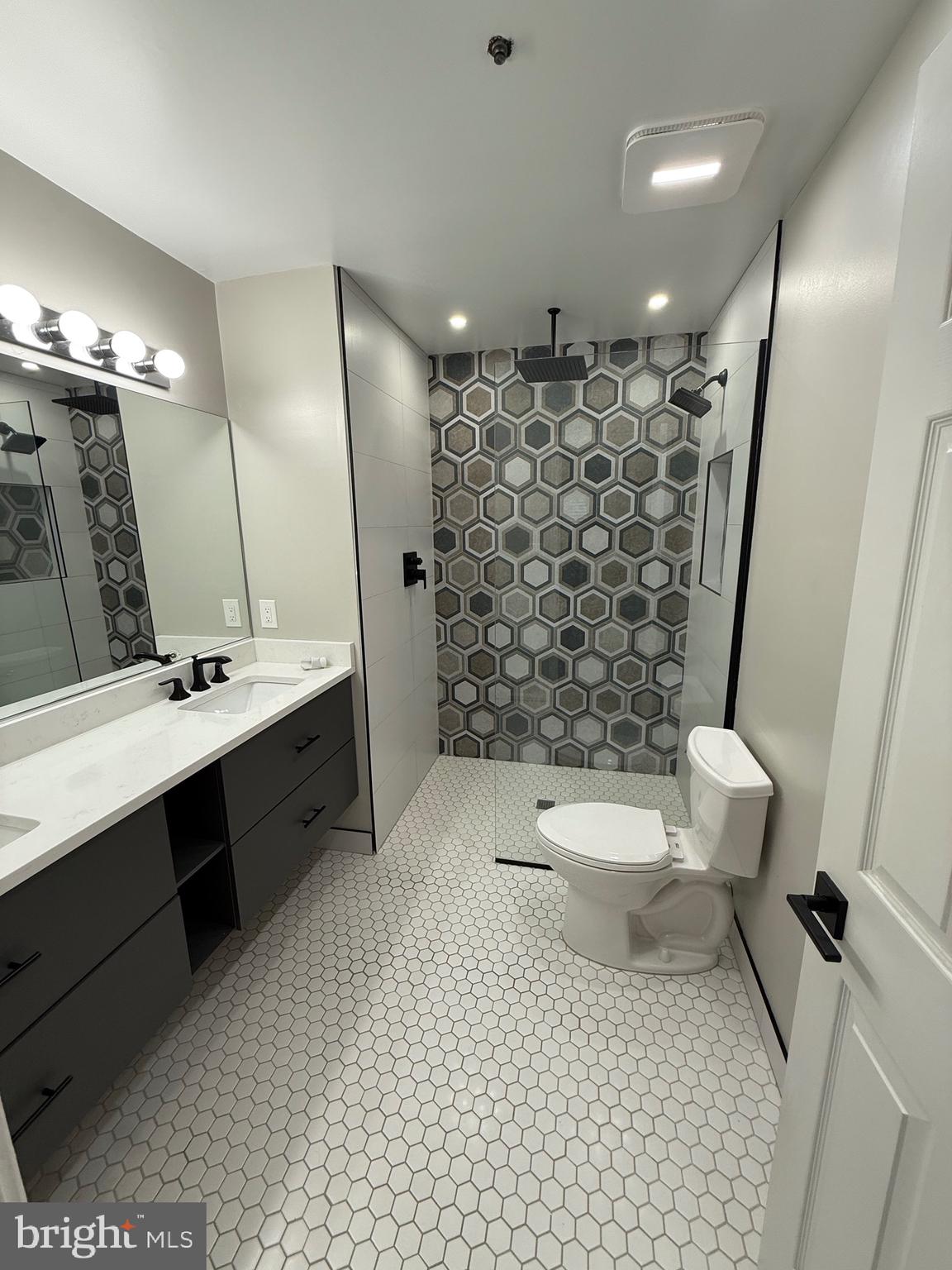 11281 Raging Brook Drive, Unit 307 Bowie, MD 20720 - Photo 11 of 11 a bathroom with a sink toilet a mirror and shower