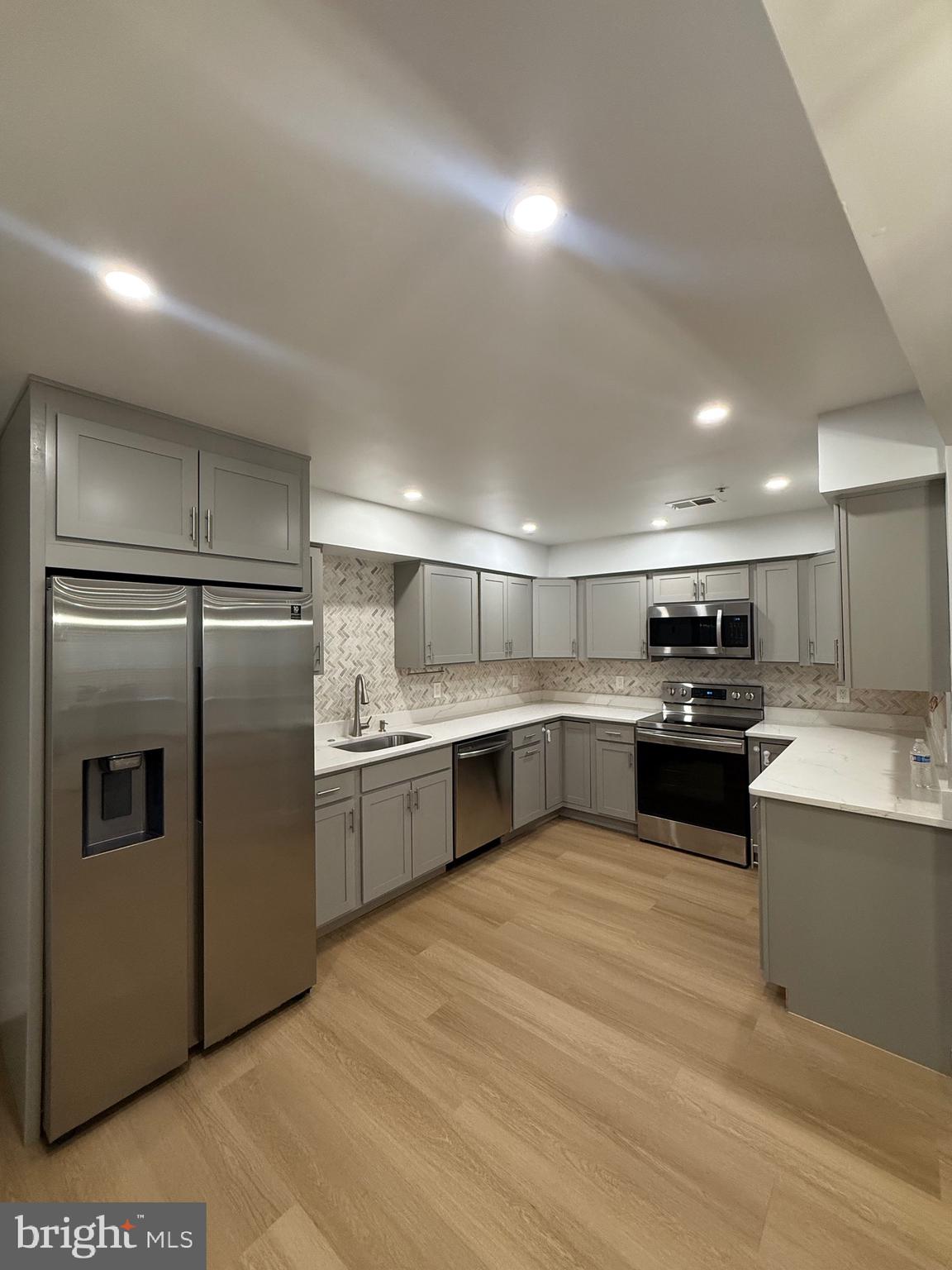 11281 Raging Brook Drive, Unit 307 Bowie, MD 20720 - Photo 4 of 11 a large kitchen with a large stainless steel refrigerator and a sink