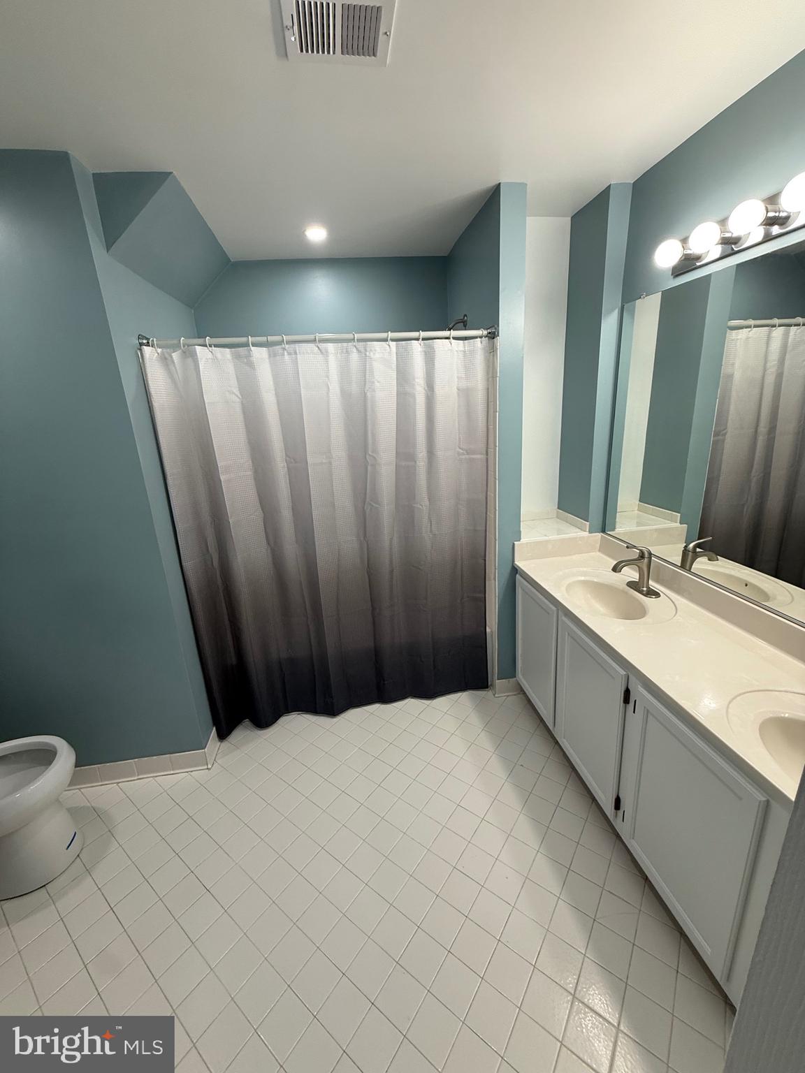 11281 Raging Brook Drive, Unit 307 Bowie, MD 20720 - Photo 8 of 11 a bathroom with a granite countertop sink and a mirror