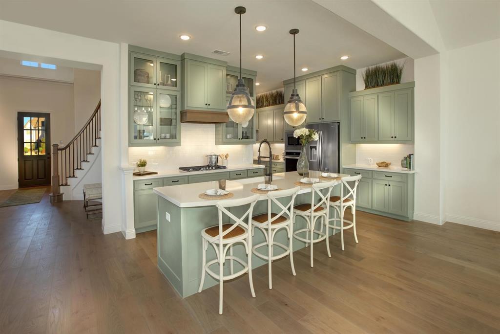 240 South Bee Balm Road McKinney, TX 75071 - Photo 6 of 23 a dining area with stainless steel appliances kitchen island granite countertop a table chairs and a refrigerator