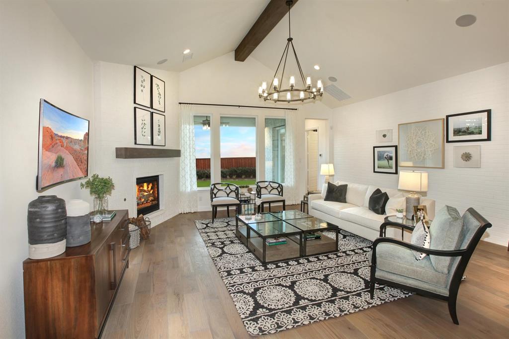 240 South Bee Balm Road McKinney, TX 75071 - Photo 8 of 23 a living room with furniture a fireplace and a chandelier