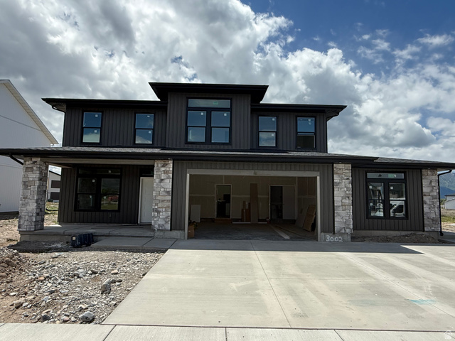 1008 West 3410 South Nibley, UT 84321 - Photo 1 of 26 Contemporary two-story exterior featuring dark vertical siding and a stone facade
