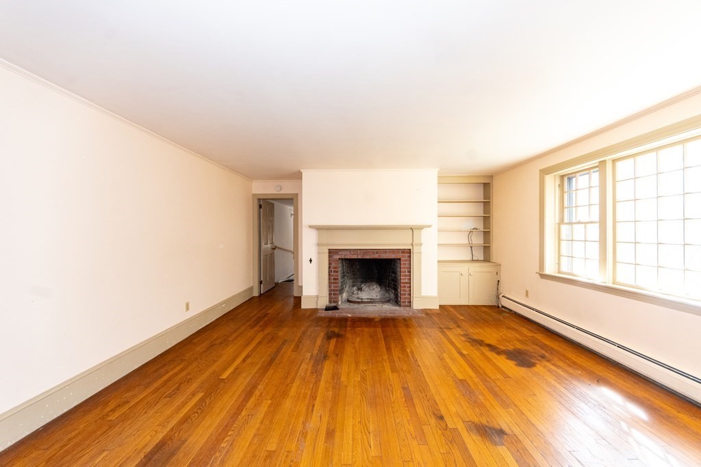 1489 Main Road Westport, MA 02790 - Photo 11 of 24 a view of an empty room with a fireplace and a window