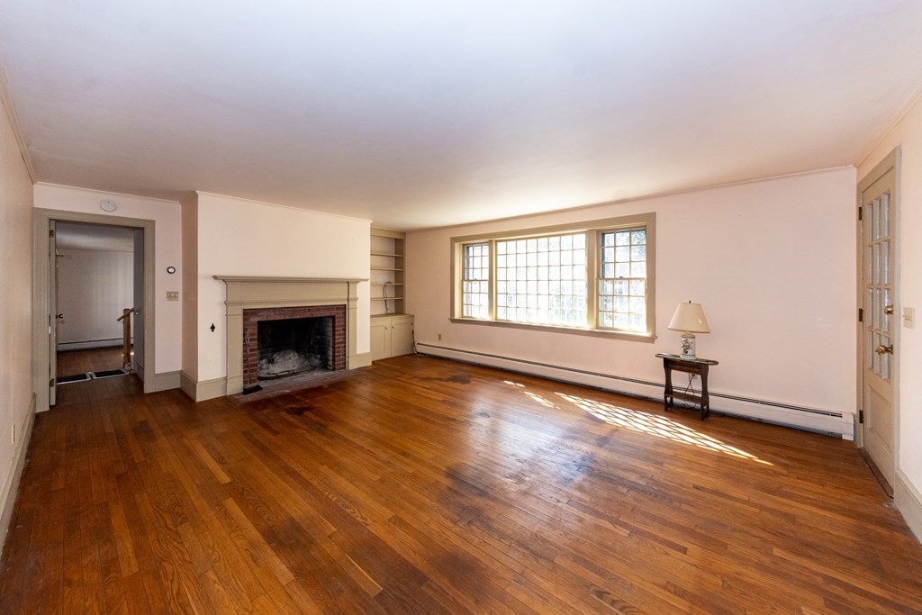 1489 Main Road Westport, MA 02790 - Photo 8 of 24 a view of empty room with wooden floor and fireplace