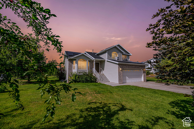 595 West 2775th Street South Logan, UT 84321 - Photo 1 of 1 View of front of house with a garage and a yard
