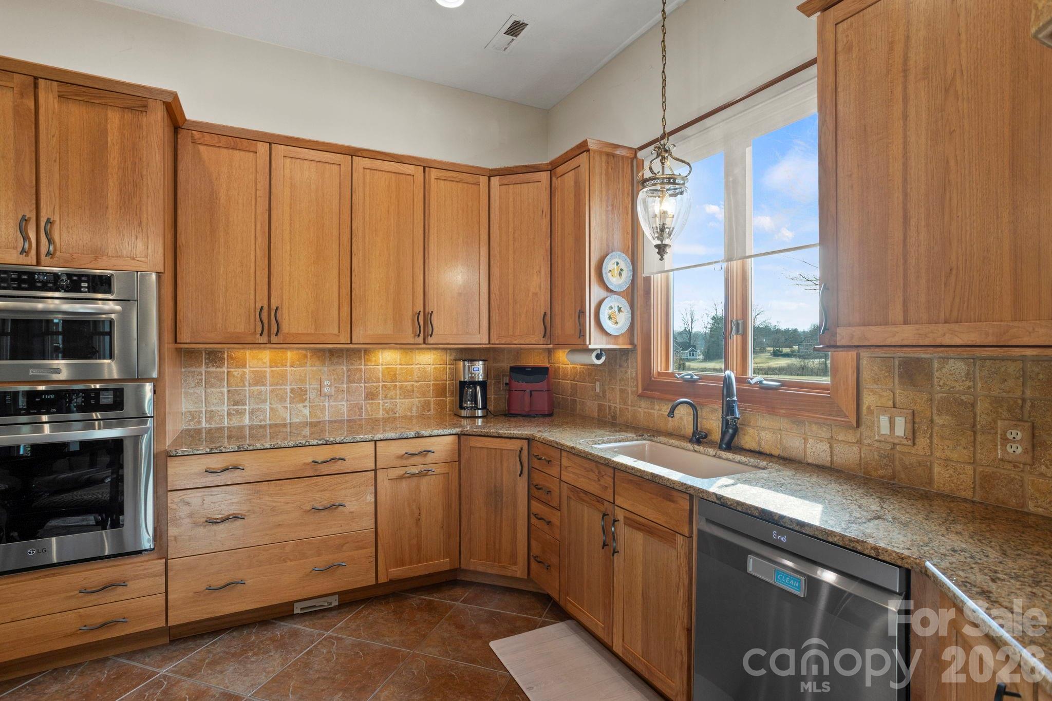 628 Vista Falls Road Mills River, NC 28759 - Photo 16 of 37 a kitchen with stainless steel appliances granite countertop a sink a stove and cabinets