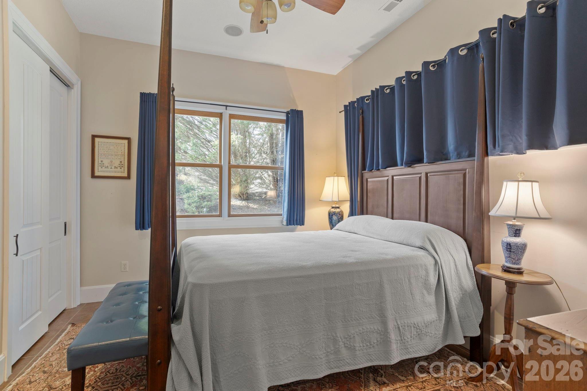 628 Vista Falls Road Mills River, NC 28759 - Photo 24 of 37 a bedroom with a bed a mirror and a window