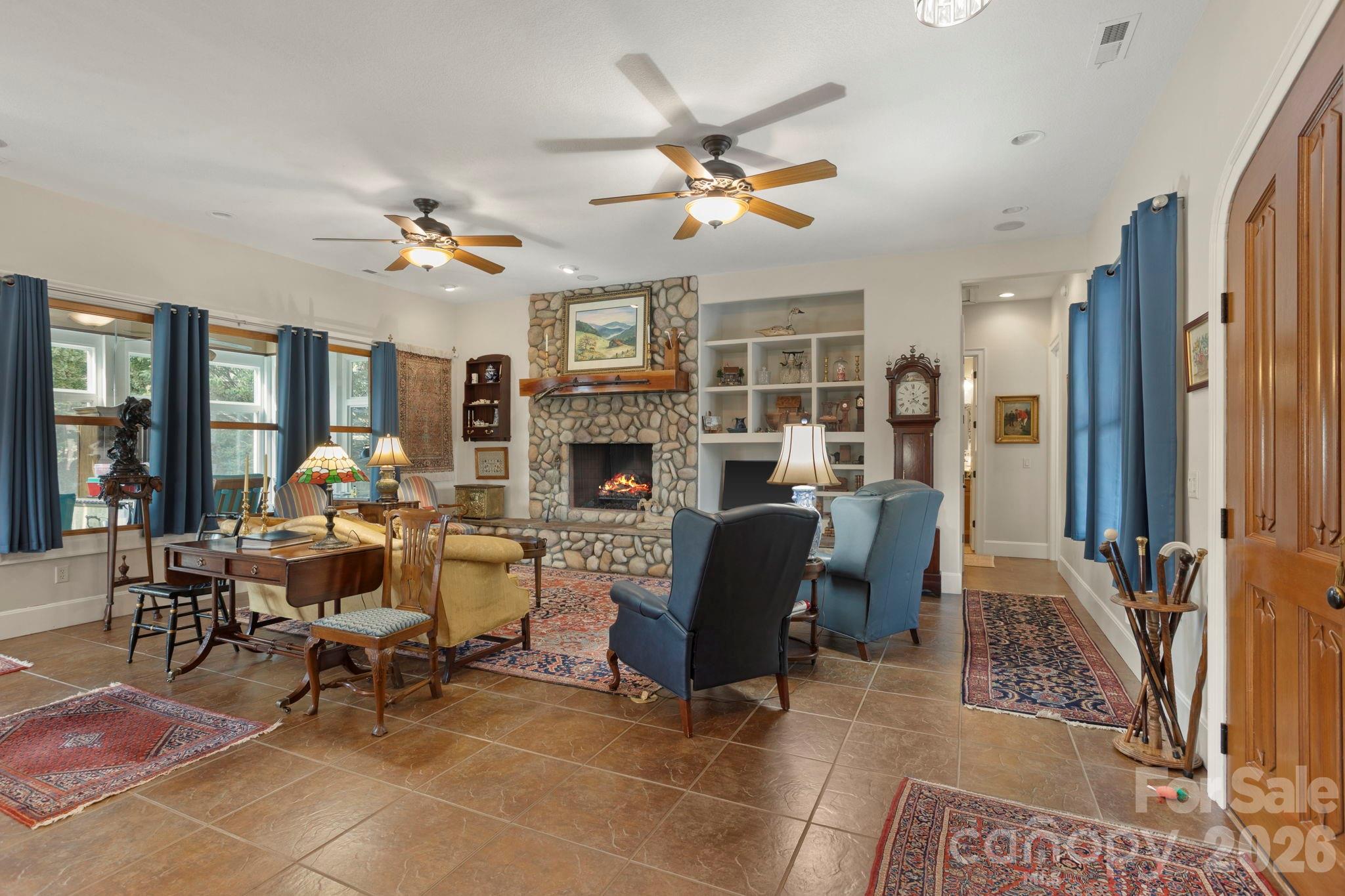 628 Vista Falls Road Mills River, NC 28759 - Photo 8 of 37 a living room with furniture dining table and a fireplace