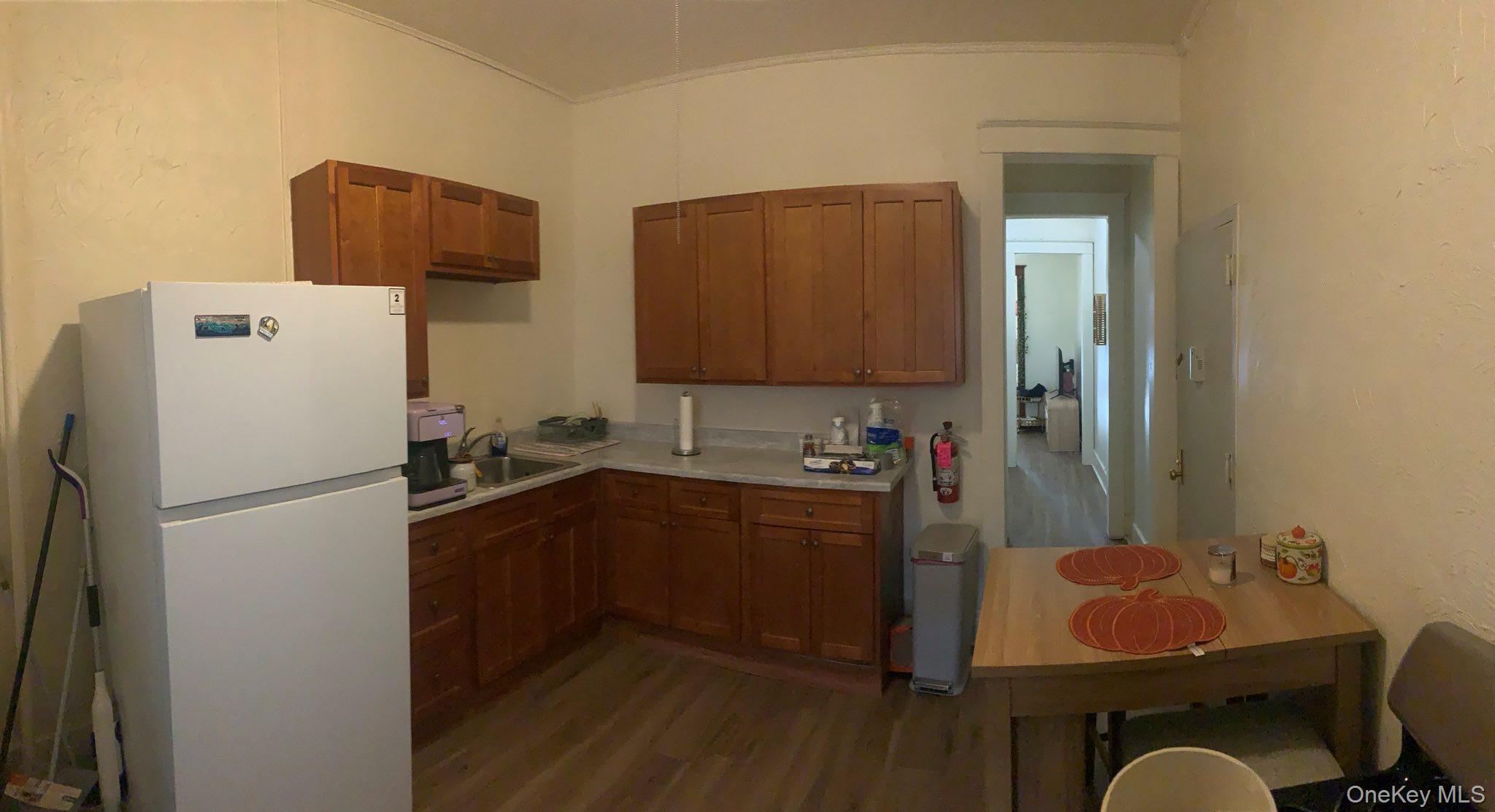 21 West Main Street, Unit B Middletown, NY 10940 - Photo 2 of 7 Kitchen with freestanding refrigerator, brown cabinetry, light countertops, and light wood-type flooring