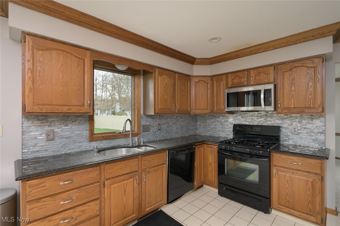 819 Bridge Road Akron, OH 44312 - Photo 19 of 33 Kitchen featuring crown molding, cabinetry, and ceramic flooring.