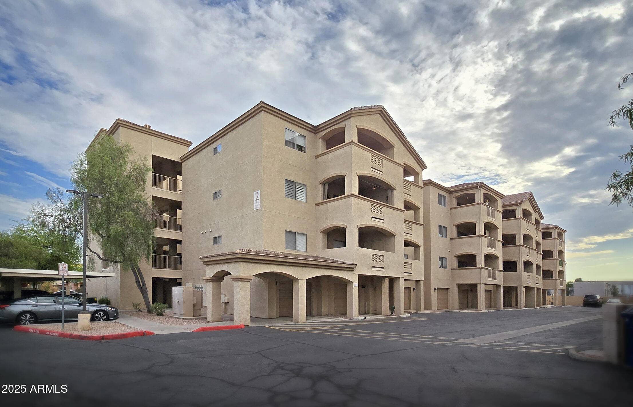 a front view of a building with lot of cars parked on road