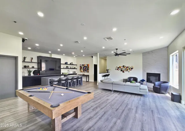 a living room with furniture a wooden floor and kitchen