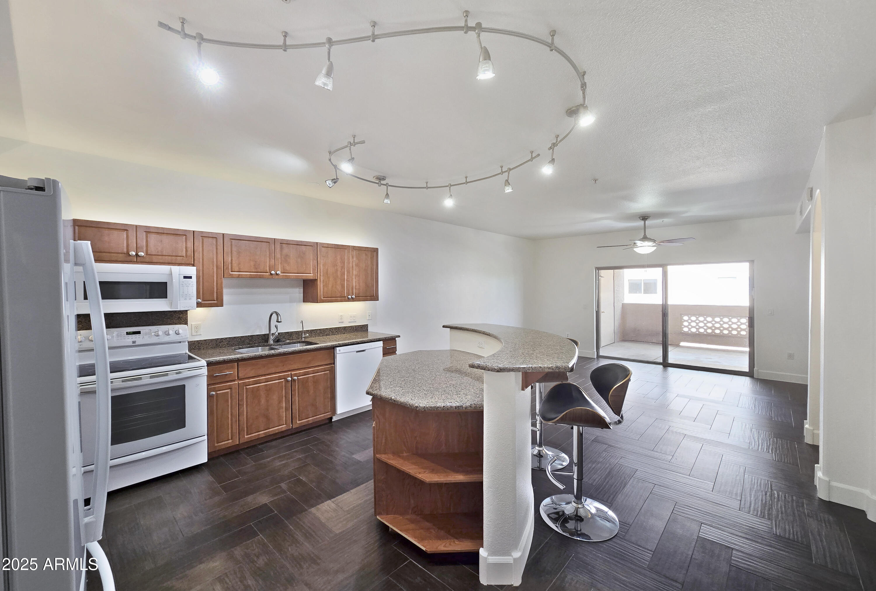 920 East Devonshire Avenue, Unit 2009 Phoenix, AZ 85014 - Photo 3 of 24 a kitchen with stainless steel appliances granite countertop a stove top oven a sink dishwasher a dining table and chairs with wooden floor